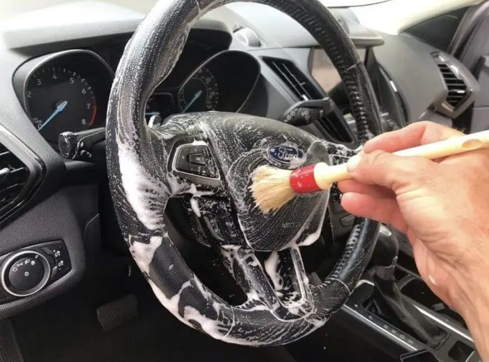 Scrub the steering wheel with a brush.