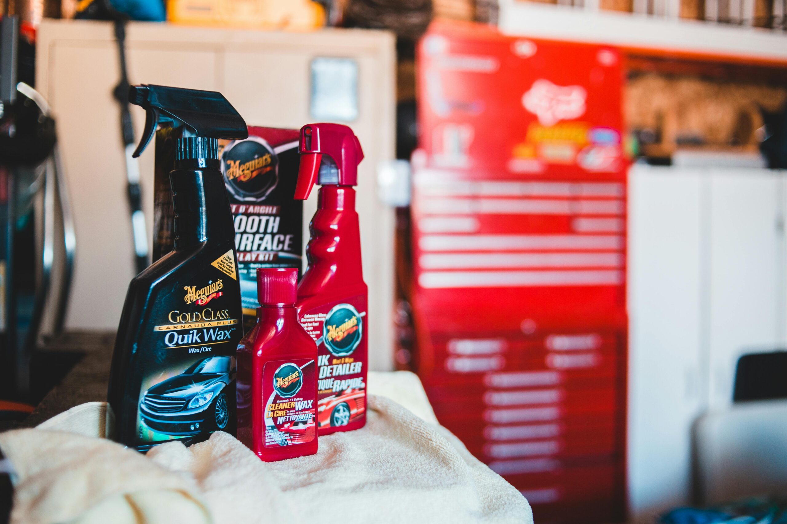 A collection of car care products displayed in a vibrant garage environment.